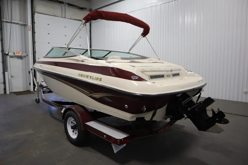 Slide: The Image of 2003 Crownline 202 BR boat with maroon and white design in a garage setting. - 7