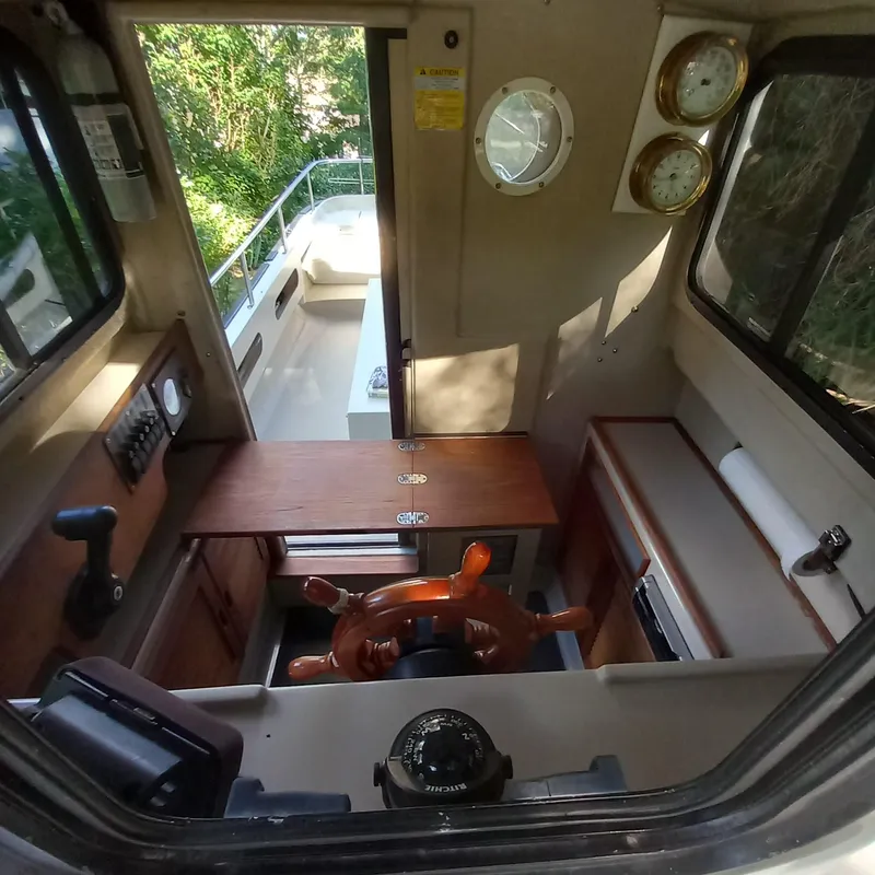 Slide: The Image of Interior of a 2005 Ranger Tugs R-21 boat with wooden steering wheel and gauges. - 12