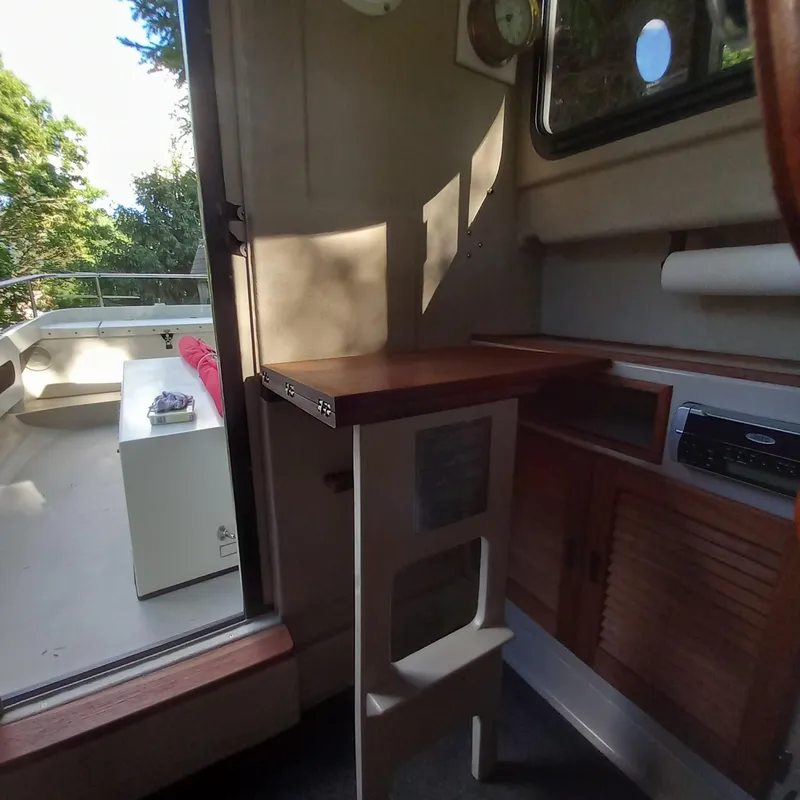 Slide: The Image of Interior of 2005 Ranger Tugs R-21 boat with wooden table and outdoor view. - 15