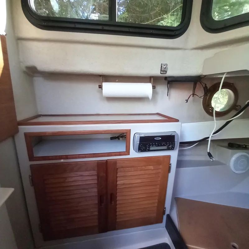 Slide: The Image of Interior of a 2005 Ranger Tugs R-21 boat with wooden cabinets and a stereo system. - 17