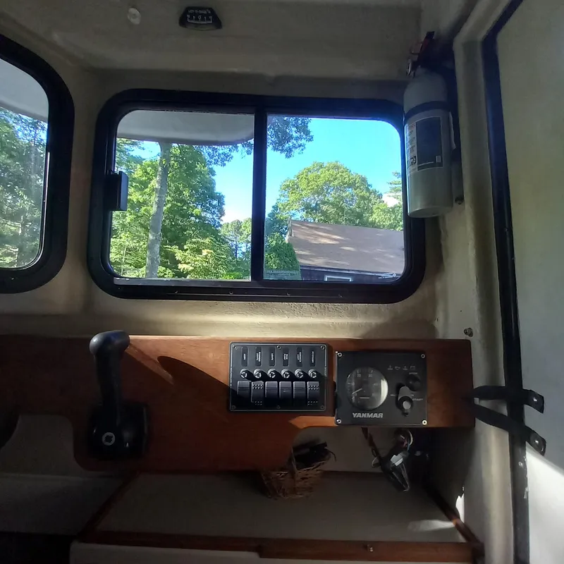 Slide: The Image of Interior view of a 2005 Ranger Tugs R-21 boat with control panel and window. - 18