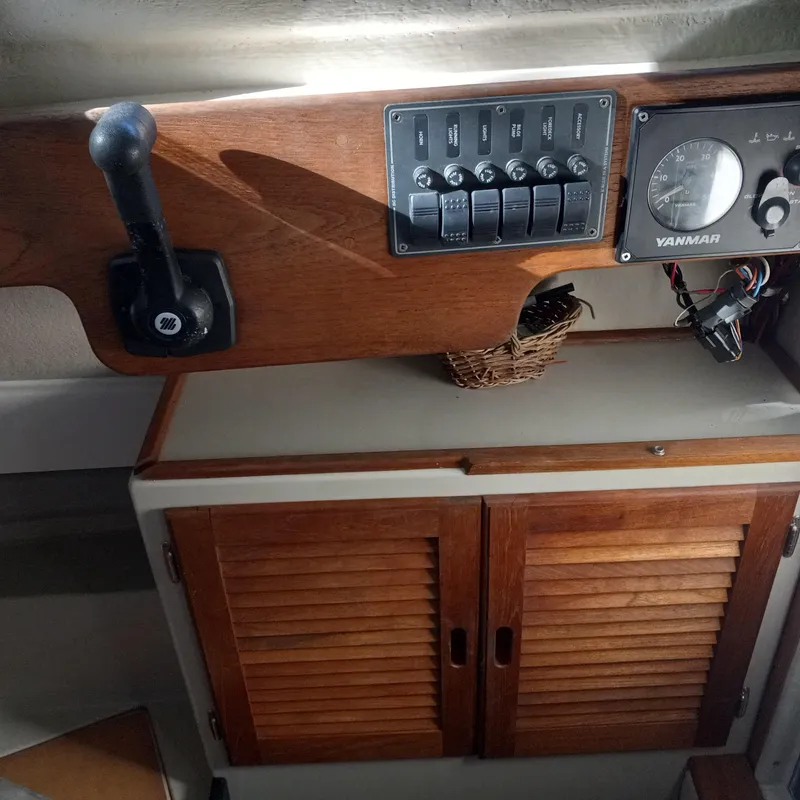 Slide: The Image of 2005 Ranger Tugs R-21 interior dashboard with controls and wooden cabinetry. - 20