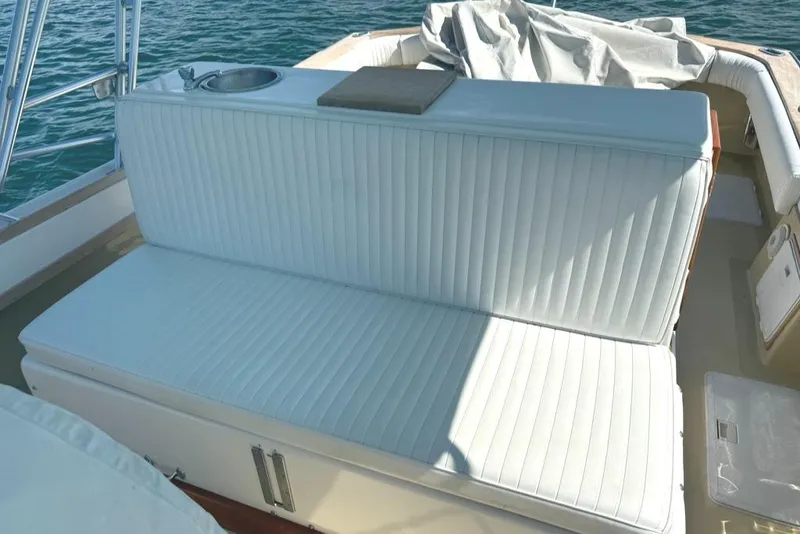 Slide: The Image of White cushioned seating on 1986 Dusky 26 Custom boat, with ocean backdrop. - 17