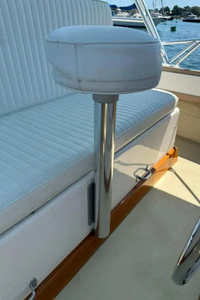 Slide: The Image of 1986 Dusky 26 Custom boat interior with white cushioned seating and chrome details. - 23