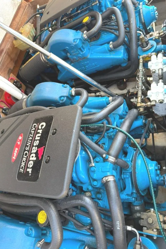 Slide: The Image of Twin Crusader engines in a 1986 Dusky 26 Custom boat, showcasing blue engine components. - 26