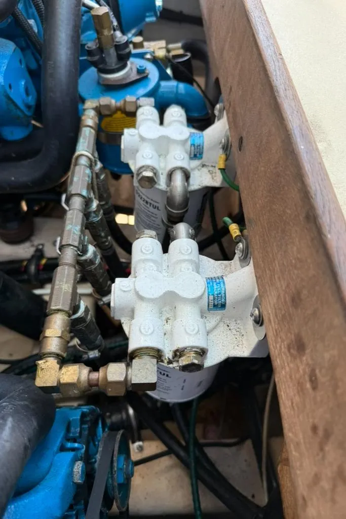 Slide: The Image of Engine components of a 1986 Dusky 26 Custom boat, featuring filters and blue machinery. - 27