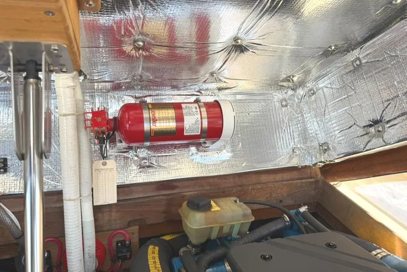 Slide: The Image of Engine compartment of 1986 Dusky 26 Custom with fire extinguisher and insulation. - 28