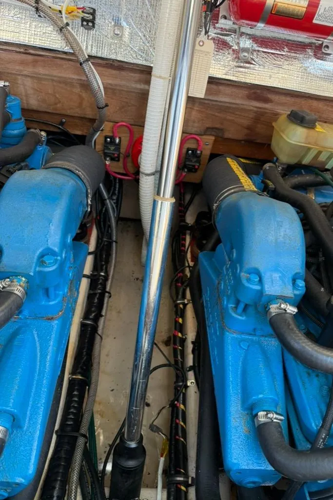 Slide: The Image of Engine compartment of a 1986 Dusky 26 Custom boat with blue engines and wiring. - 29
