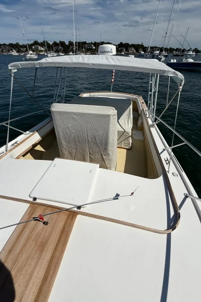 Slide: The Image of 1986 Dusky 26 Custom boat with canopy, docked in a marina, featuring Garmin equipment. - 8
