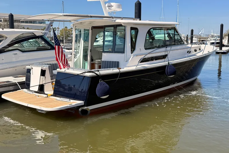 The Image of 2026 Back Cove 372 yacht docked in marina, featuring sleek design and American flag. - 0