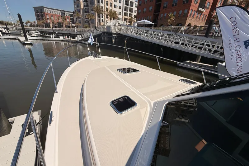 Slide: The Image of 2026 Back Cove 372 yacht docked at marina with modern buildings in background. - 13