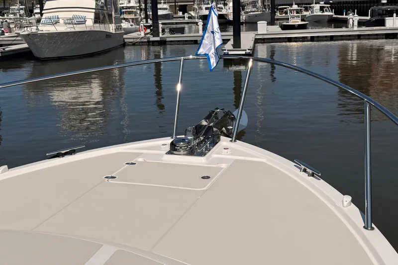 Slide: The Image of Bow of 2026 Back Cove 372 yacht docked at marina, featuring sleek design and flag. - 14
