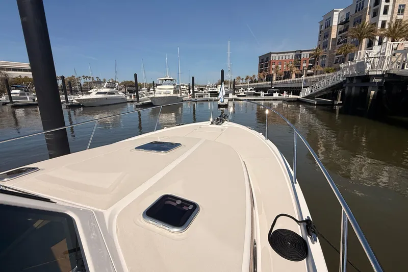 Slide: The Image of 2026 Back Cove 372 yacht docked in a marina with modern buildings in the background. - 16