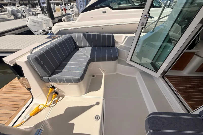 Slide: The Image of 2026 Back Cove 372 boat with striped seating and open cabin door at a marina. - 22