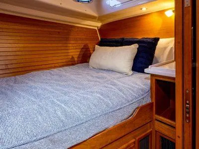 Slide: The Image of 2026 Back Cove 372 cabin interior with cozy bed and wooden paneling. - 30