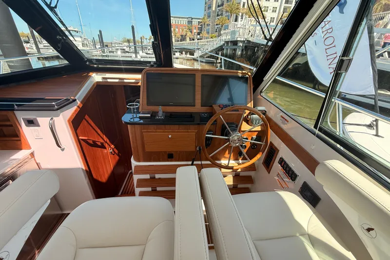 Slide: The Image of Interior helm of 2026 Back Cove 372 yacht with wooden accents and modern controls. - 32