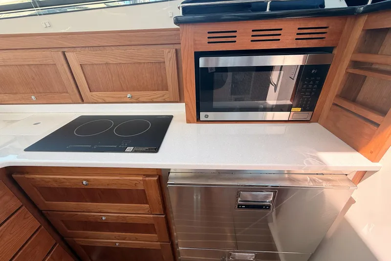 Slide: The Image of Modern kitchen in 2026 Back Cove 372 yacht with stove, microwave, and wooden cabinetry. - 37