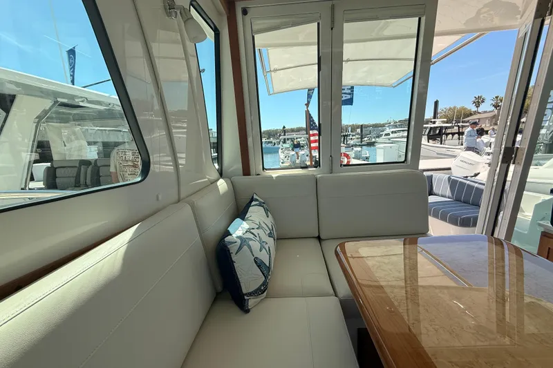 Slide: The Image of Interior of 2026 Back Cove 372 yacht with plush seating and marina view. - 42