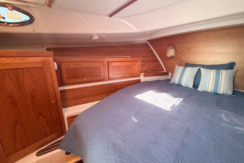 Slide: The Image of Cozy cabin interior of 2026 Back Cove 372 yacht with wooden accents and blue bedding. - 43