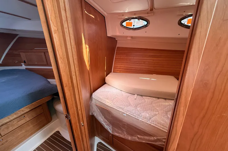 Slide: The Image of 2026 Back Cove 372 yacht interior with wooden cabinetry and cozy sleeping quarters. - 47