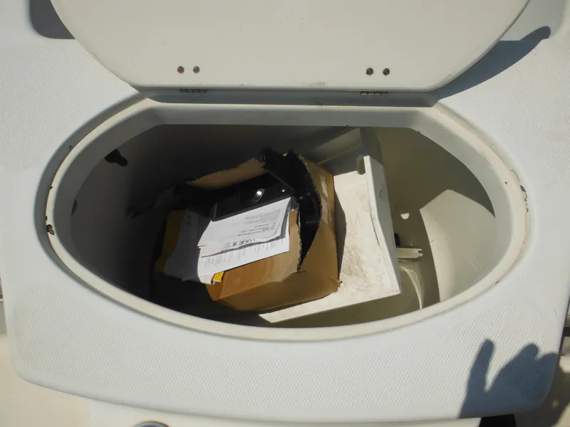 Slide: The Image of Open storage compartment on 2004 Hydra-Sports Lightning 202 DC boat with miscellaneous items inside. - 18