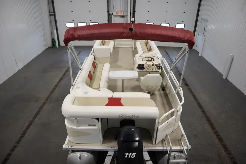 Slide: The Image of 2008 Bentley Pontoons 240 CRUISE boat with red canopy and spacious seating in a garage. - 10