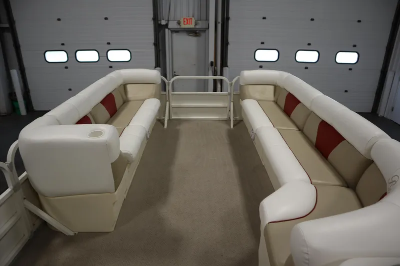 Slide: The Image of 2008 Bentley Pontoons 240 CRUISE interior with beige and red seating in a garage. - 11