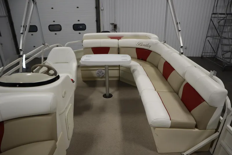 Slide: The Image of 2008 Bentley Pontoons 240 CRUISE interior with beige and red seating, steering wheel, and table. - 31