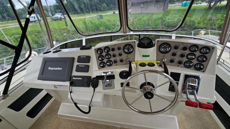 Slide: The Image of 1997 Carver 355 Motor Yacht helm with Raymarine navigation system and control panel. - 12