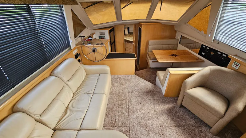 Slide: The Image of Interior of 1997 Carver 355 Motor Yacht with beige seating and dining area. - 16