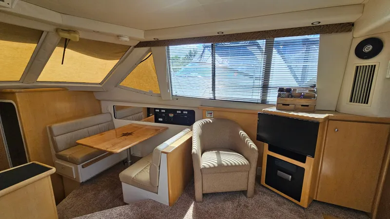 Slide: The Image of Interior of 1997 Carver 355 Motor Yacht with seating, table, and windows. - 18
