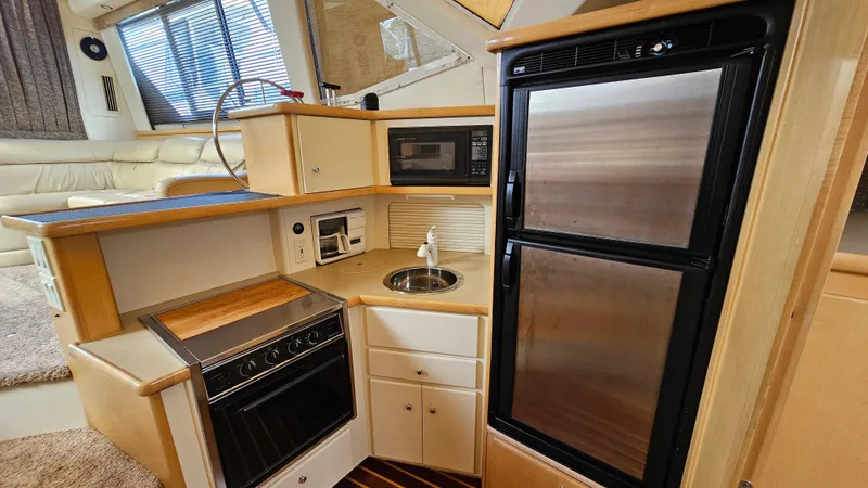 Slide: The Image of 1997 Carver 355 Motor Yacht kitchen with fridge, oven, microwave, and sink. - 21