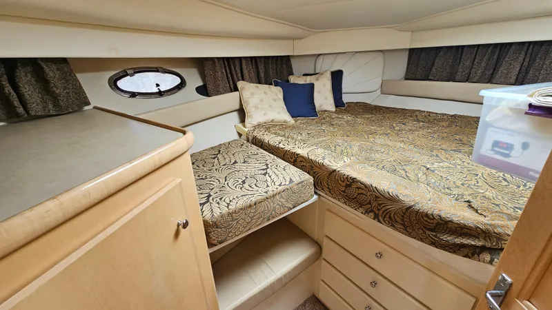 Slide: The Image of 1997 Carver 355 Motor Yacht cabin with elegant bedding and storage drawers. - 23