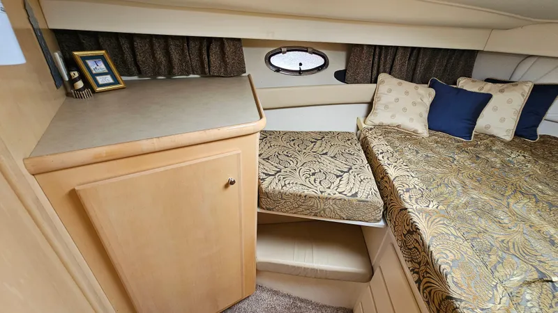 Slide: The Image of 1997 Carver 355 Motor Yacht interior with elegant bedding and wooden cabinetry. - 24