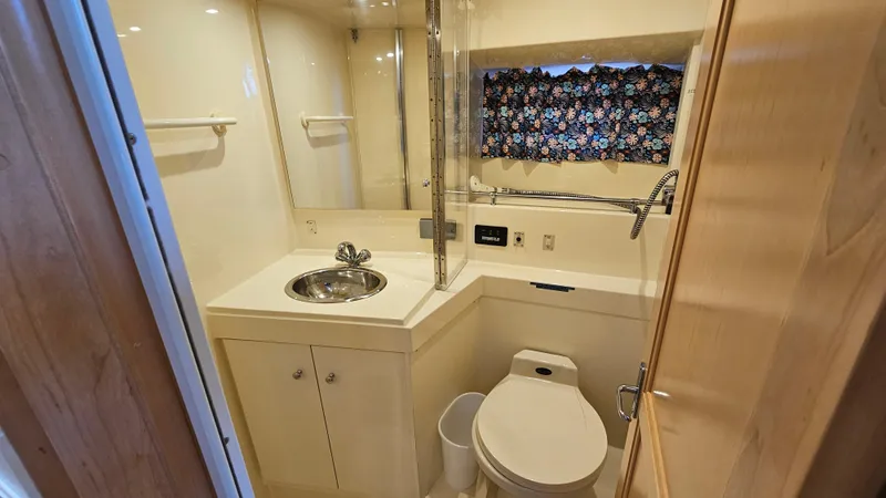 Slide: The Image of Bathroom interior of 1997 Carver 355 Motor Yacht with sink, toilet, and floral curtain. - 26