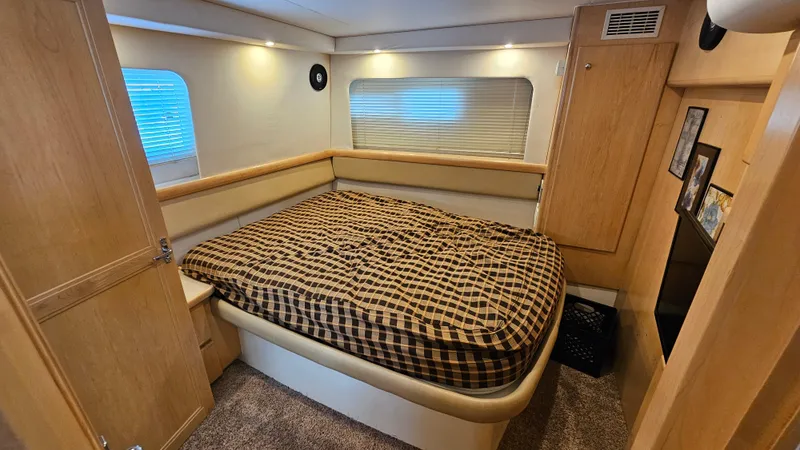 Slide: The Image of Cozy bedroom in 1997 Carver 355 Motor Yacht with plaid bedding and wood accents. - 27