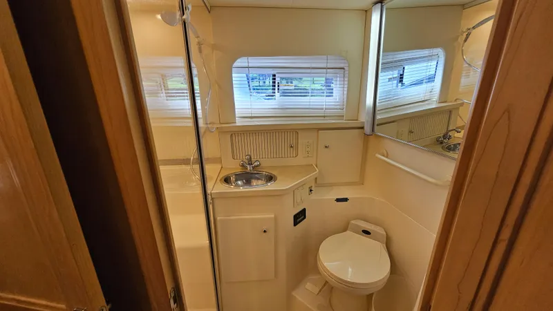 Slide: The Image of 1997 Carver 355 Motor Yacht bathroom with sink, toilet, and window blinds. - 29