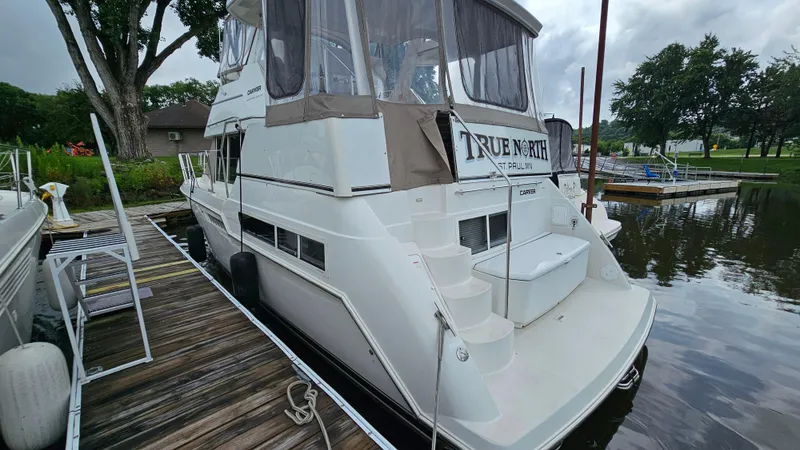 Slide: The Image of 1997 Carver 355 Motor Yacht docked, featuring spacious deck and elegant design. - 3