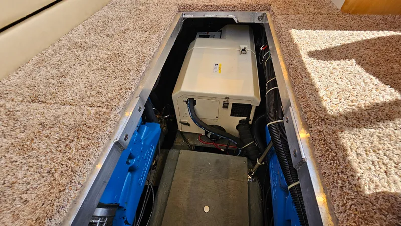 Slide: The Image of Engine compartment of a 1997 Carver 355 Motor Yacht, featuring carpeted flooring and visible machinery. - 33