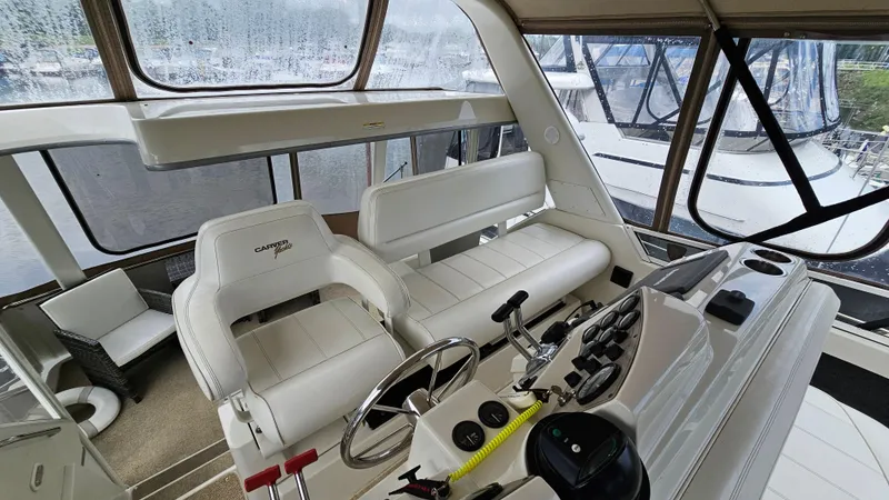 Slide: The Image of 1997 Carver 355 Motor Yacht interior with helm, white seating, and control panel. - 8
