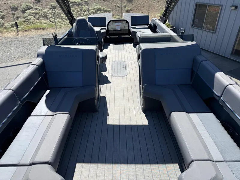 Slide: The Image of Interior of 2025 Manitou Explore Dual Engine boat with spacious seating and modern design. - 13