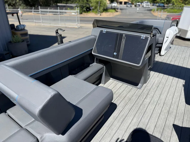 Slide: The Image of 2025 Manitou Explore Dual Engine boat interior with sleek seating and modern dashboard. - 20