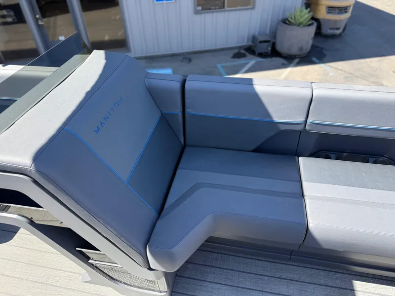 Slide: The Image of Luxurious seating on 2025 Manitou Explore Dual Engine boat, featuring sleek gray upholstery. - 21