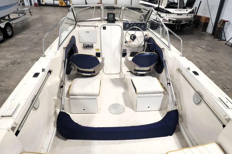 Slide: The Image of 1999 Campion Explorer 552 boat interior with blue and white seating, steering wheel, and dashboard. - 6