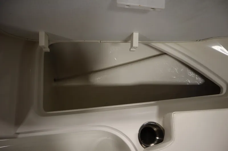 Slide: The Image of 2022 Bayliner E18 Element storage compartment with cup holder, showcasing interior design. - 14