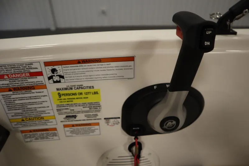 Slide: The Image of 2022 Bayliner E18 Element boat controls with warning labels and capacity information. - 22