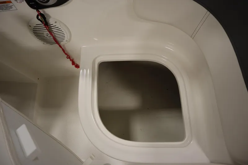 Slide: The Image of 2022 Bayliner E18 Element boat interior storage compartment with speaker and safety cord. - 24