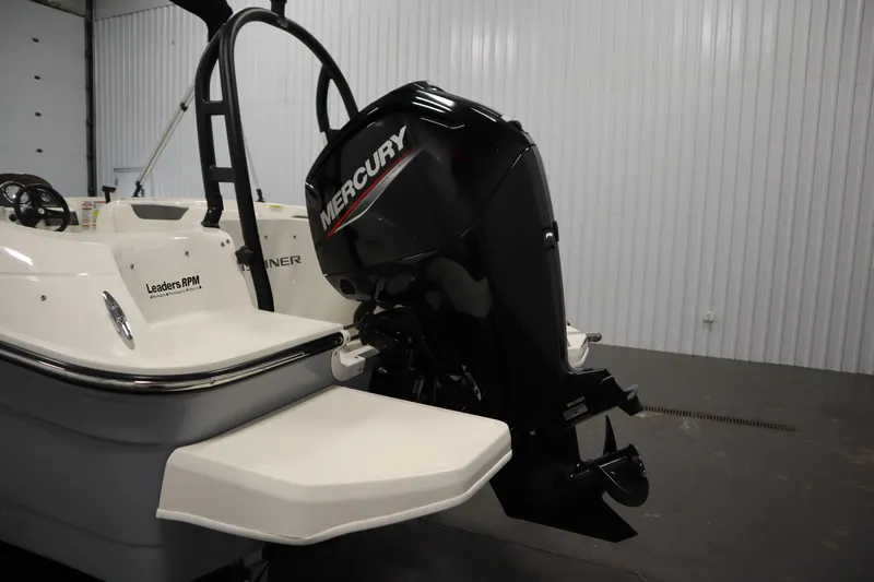 Slide: The Image of 2022 Bayliner E18 Element with Mercury outboard motor in a garage setting. - 34