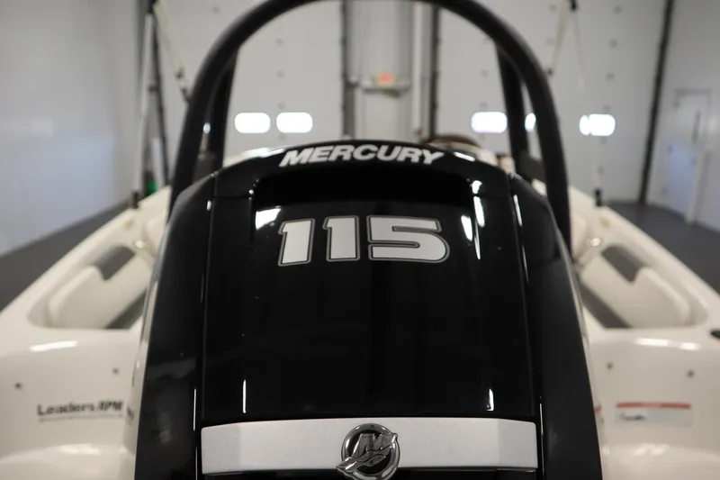 Slide: The Image of 2022 Bayliner E18 Element with Mercury 115 engine in a garage setting. - 36