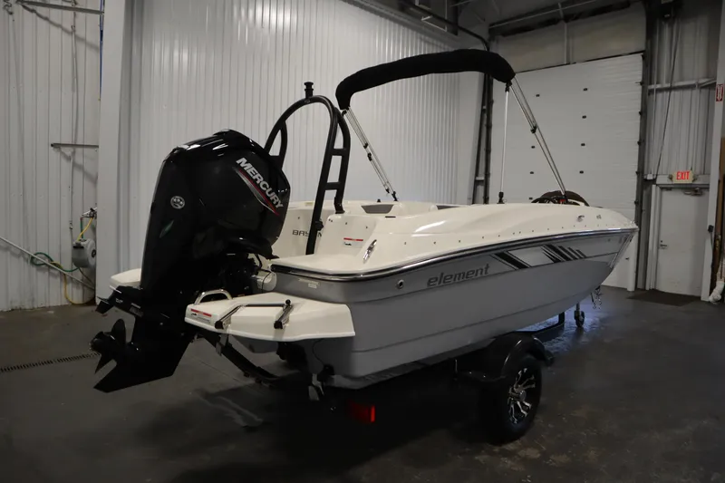 Slide: The Image of 2022 Bayliner E18 Element boat with Mercury outboard motor in a garage setting. - 5